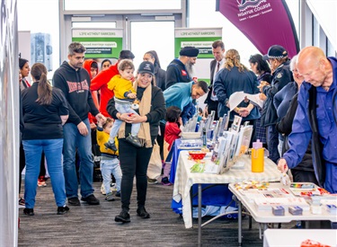 Woman carrying a toddler walking through information desk