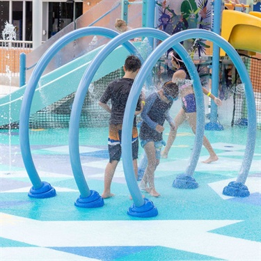 Children running through water rings