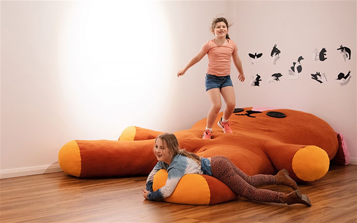Children playing on a large stuffed bear. PlaySpectrum. Photo by Hamilton Gallery, 2002.