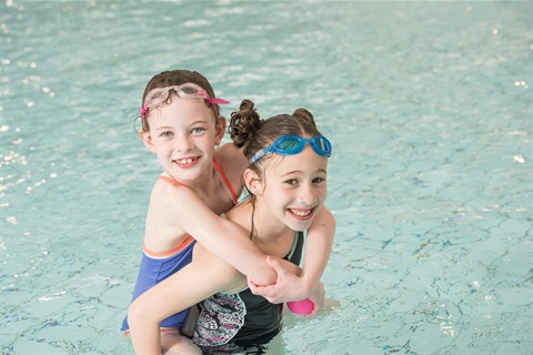 Two little girls swimming in a pool