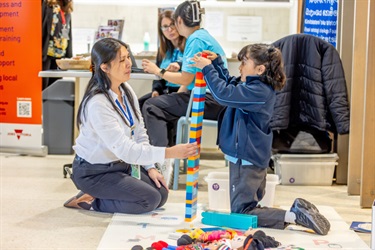 Children's Workshop - a preschool child is building a tower with plastic blocks