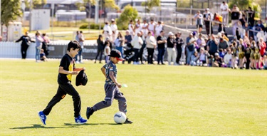 Children playing soccer on grass oval