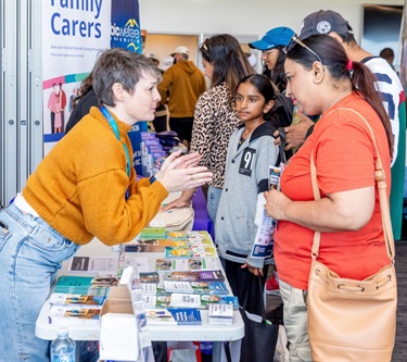 Hume Council Officer speaking at an information table, speaking with a community member 