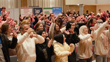 Audience dancing following the instructions from stage 