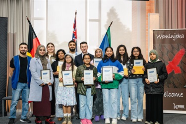 Group of people and kids with certificates on stage 