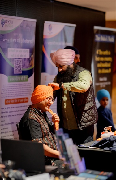 A man helping another man with their traditional attire